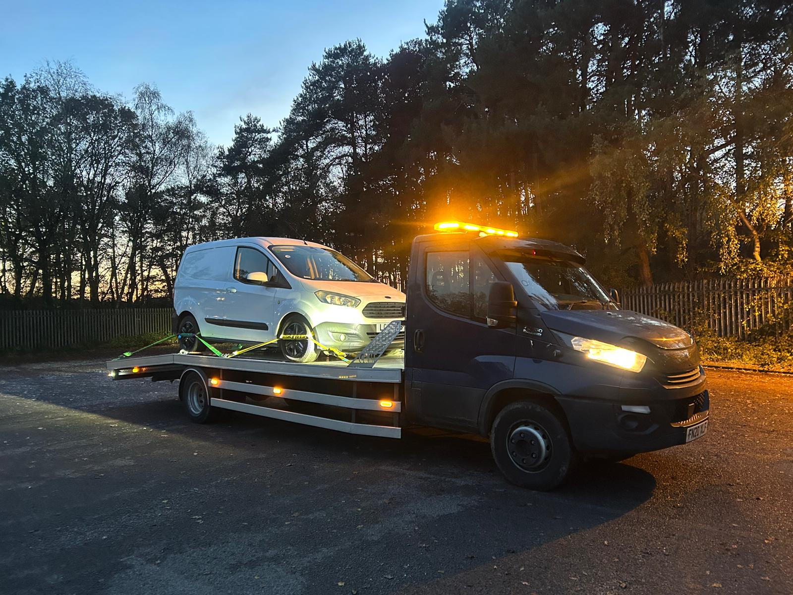 Van loaded on an East Sussex Recovery truck at sunset